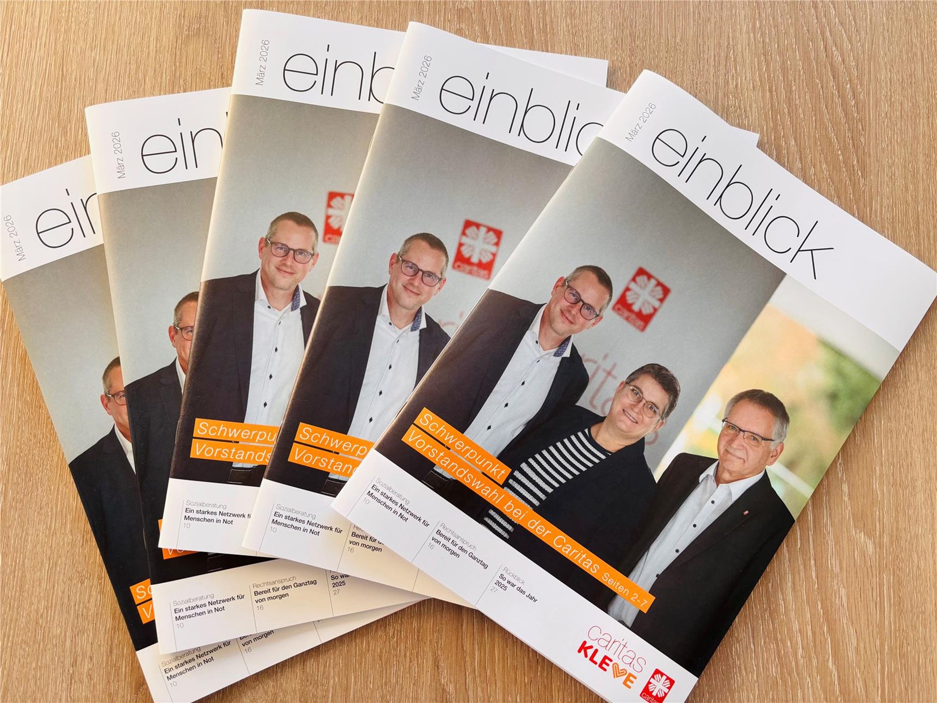 Fünf Ausgaben des Caritas-Magazins "einblick" auf einem Tisch liegend